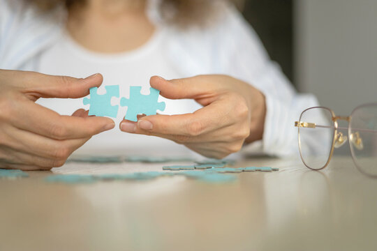 Business woman hands assembling puzzle details concept of finding solution solving problem top view