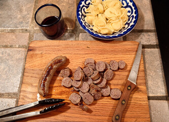 preparing an Italian meal with sausage and tortellini pasta 