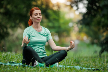 Fototapeta premium Peaceful Senior Woman Practicing Yoga Meditation Outdoors
