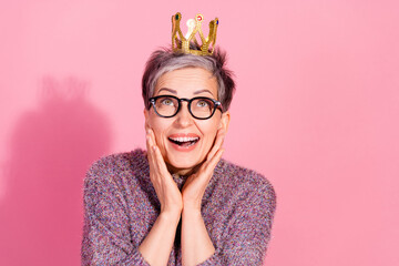 Photo of impressed positive woman wear sweater crown amrs cheeks empty space isolated pink color...