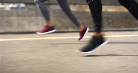 Fitness, feet and people running in city for exercise, training or fast race on road. Athletes, legs and speed on street for marathon preparation, workout and endurance challenge in competitive group