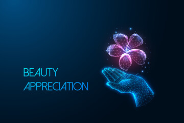 Beauty appreciation concept with glowing digital flower floating above hand on dark blue background.