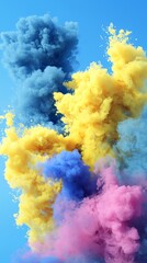 Fototapeta premium Vibrant explosion of blue, yellow, and pink smoke against a clear blue background, creating an energetic and dynamic atmosphere.
