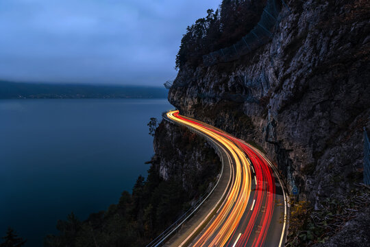 The spetacular motorway on cliff with traffic light trail in the evening