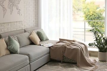 Fototapeta premium Stylish living room interior with comfortable sofa near brick wall