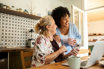 Lesbian couple frustrated while talking about bills during breakfast at kitchen table