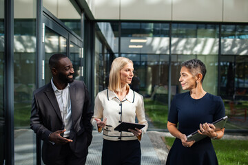 Business professionals discussing project outside office building