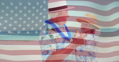 Fototapeta premium Dancing elderly couple on beach over American flag image