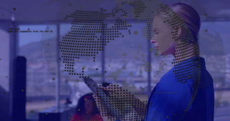 Image of globe and data processing over caucasian businesswoman using tablet in office