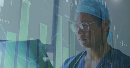 Image of financial data processing over asian male doctor holding x-ray scan