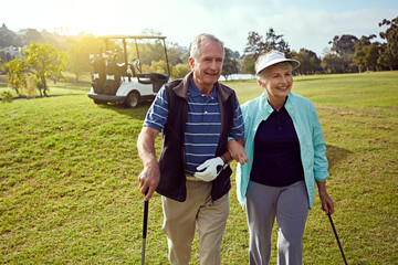 Golf, hobby and walking with senior couple outdoor on green course together for leisure activity. Grass, love and retirement with mature people playing sports for bonding or recreation in summer