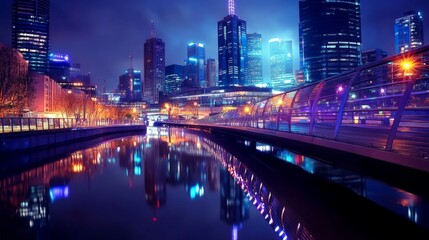 A modern city bridge lit up at night, with buildings and reflections on the water