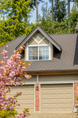 Garage door in luxury house with trees and nice landscape in Summer in Vancouver, Canada, North America. Day time on June 2024.