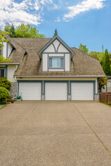 Garage door in luxury house with trees and nice landscape in Summer in Vancouver, Canada, North America. Day time on June 2024.