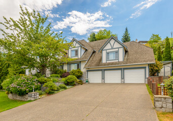 Garage door in luxury house with trees and nice landscape in Summer in Vancouver, Canada, North America. Day time on June 2024.