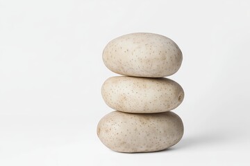 Fototapeta premium Stacked potatoes balancing on white background