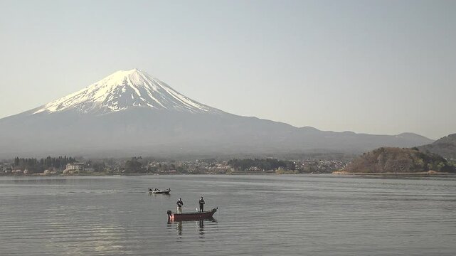 富士山を背景に湖に小舟を浮かべ釣りをする人々、固定撮影