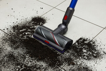Cleaning floor with cordless vacuum cleaner indoors, closeup
