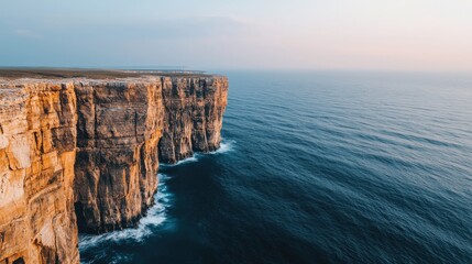 A breathtaking coastal view featuring towering cliffs beside a tranquil sea during sunset, highlighting the beauty of nature's landscape.