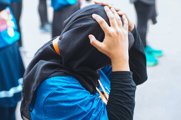 a dizzy Muslim holding his head