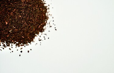 Pile of fragrant earl grey organic tea leaves isolated on horizontal copy spaced white background.