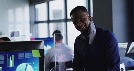 Portrait of african american with man lowered face mask using digital tablet at modern office