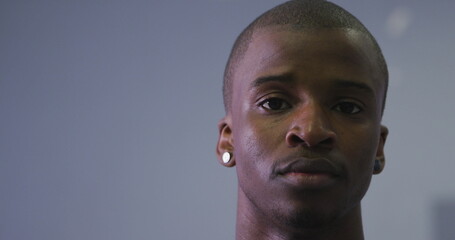 Portrait of a biracial modern male dancer, wearing black clothes, looking at the camera