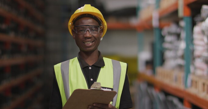 Portrait of an African American male factory worker at a factory making hydraulic equipment, wearing