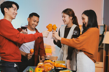 Group of young Asian man and women as friends having fun at a New Year's celebration, holding gift...
