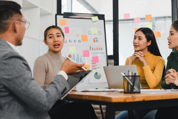 Effective team meeting with diverse professionals discussing strategies and ideas. Engaging conversation around data and presentations fosters collaboration and innovation