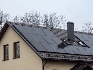 Black solar panels on the roof of the house. Solar energy solutions for family homes. Renewable...