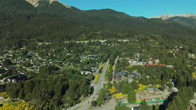 Scenic aerial view of Villa La Angostura's main urban area featuring Arrayanes Avenue. Nestled in Patagonia, Argentina, the image captures the charming blend of urban development and surrounding.