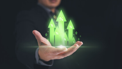 Hand holding green arrow with percentage for growth in investment profit revenue, increase of sale value, raising of tax and interest rate concept.
