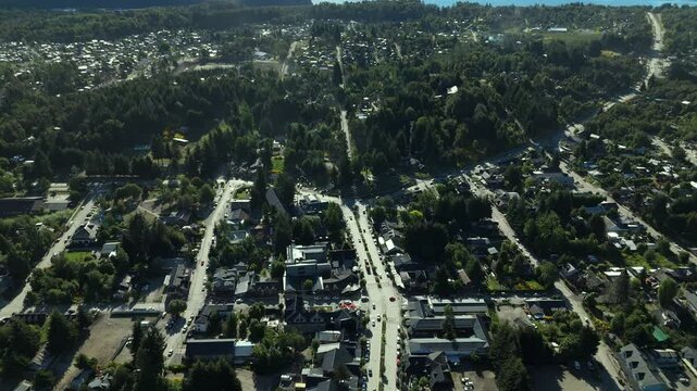 Scenic aerial view of Villa La Angostura's main urban area featuring Arrayanes Avenue. Nestled in Patagonia, Argentina, the image captures the charming blend of urban development and surrounding.