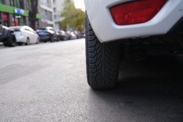 Fototapeta premium A closeup of a car tire on a busy city street, showcasing the essence of urban life and transportation