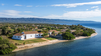 Coastal view of a serene white house along a tranquil shoreline in a lush landscape
