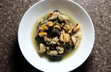 Mussel soup in a white bowl. Mussel soup boiled with Korean seaweed.