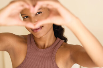 Eye Care Love: A Woman Smiling Joyfully Through Heart-Shaped Hands. Represents Connection,...