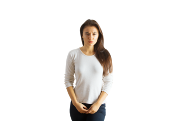 Woman in a plain white shirt and dark jeans standing with serious expression, isolated on white background. Concept of emotions, casual fashion