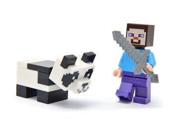 Naklejka premium Lego minifigure of character from popular video game Minecraft with panda isolated on white. Editorial illustrative image of popular plastic toys.