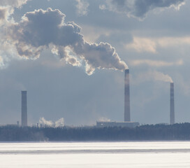 A large cloud of smoke is rising from a power plant