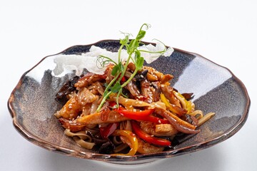 Stir-Fried Udon with Meat in Wok on a Plate Against a White Background