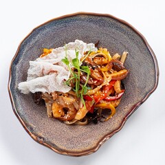 Stir-Fried Udon with Meat in Wok on a Plate Against a White Background