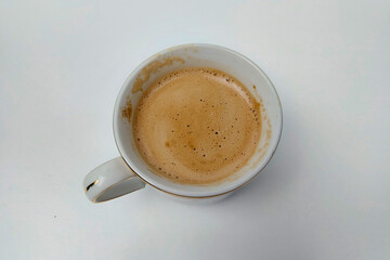 cappuccino coffee in a white glass on a white table, ready to be brewed