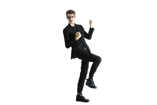 Man in a dynamic celebratory pose wearing asuit and glasses, standing on one leg, isolated on a white background, concept of success