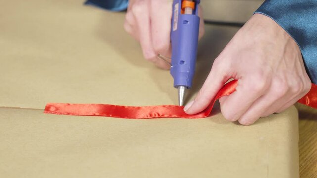Trying on red ribbon and gluing it to craft