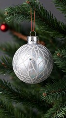 sparkling Christmas bauble hanging from a pine tree branch