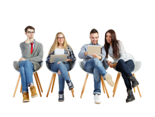 Four young adults sitting on modern chairs, using a laptop and tablet. Casual attire, white background. Concept of teamwork and collaboration