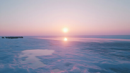 Obraz premium Serene sunset over snowy landscape with a herd of animals in the distance.