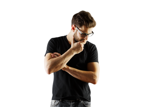 Man with glasses wearingt-shirt stands thoughtfully with hand on chin, isolated on white background. Concept of thinking or decision-making